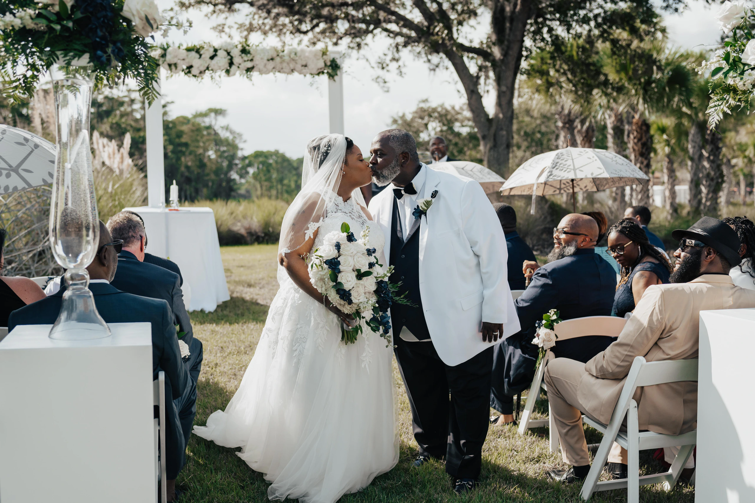 Ebony and Dervon sharing a kiss as they walk back down the aisle at their Four Seasons Resort Orlando wedding ceremony