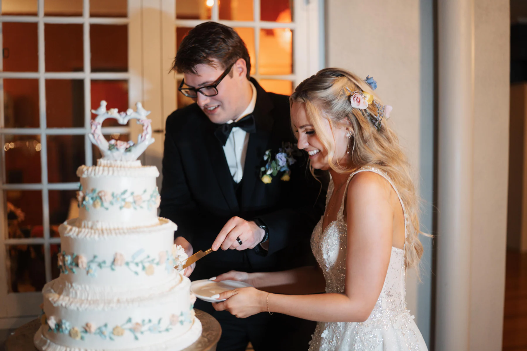 Veronica and Cole laughing together as they cut their wedding cake at Sydonie Mansion