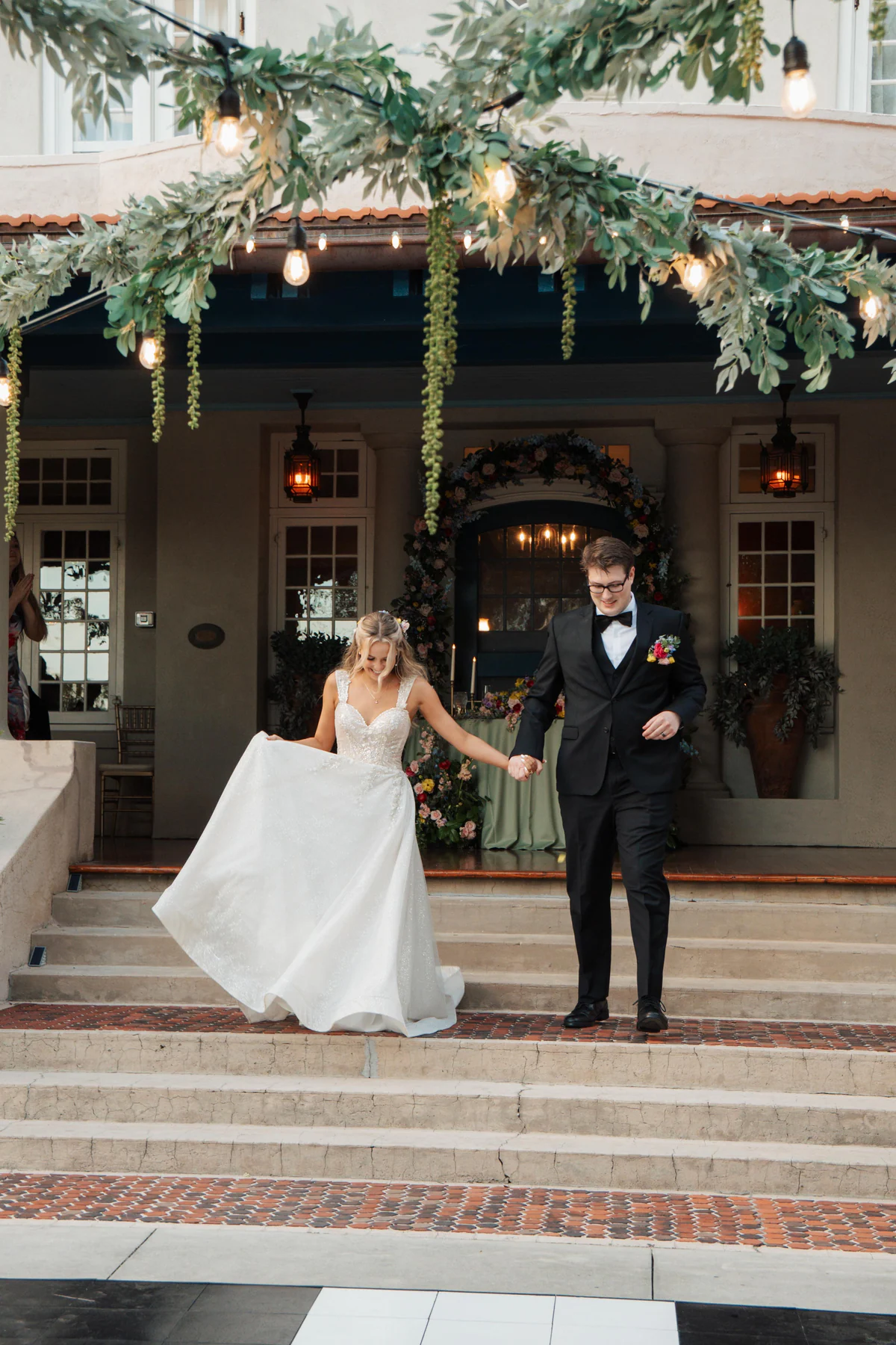 Veronica and Cole coming down the mansion steps hand in hand to start their reception at Sydonie Mansion